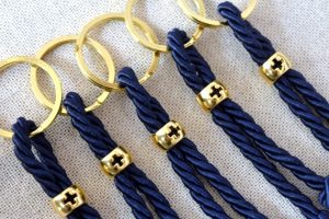 Llaveros de cordones azules con detalles dorados con la marca de una cruz