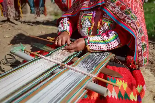 mujer teje telas milticolores, Cusco, Perú