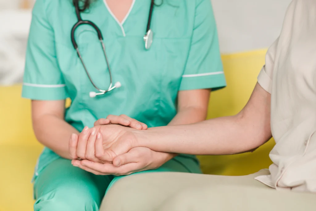Enfermera sosteniendo la mano de un paciente