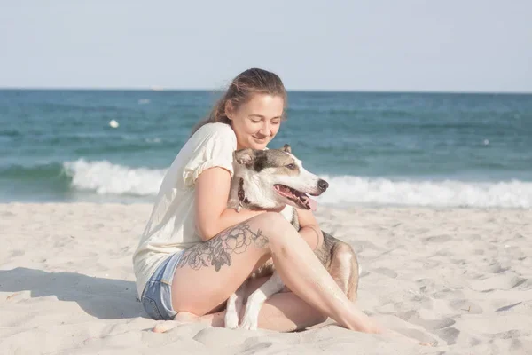 mujer con su mascota en playa un día caluroso