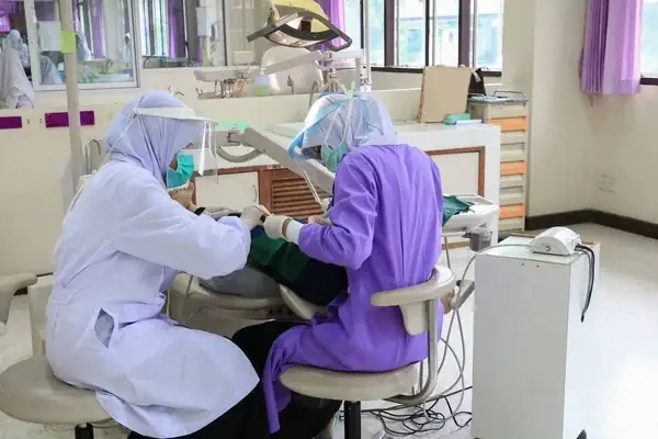 Grupo de odontólogos practicando la odontología comunitaria en un colegio