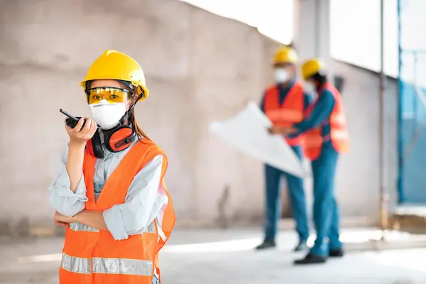 Supervisor con chaleco y casco revisando medidas de protección eléctrica en una obra en construcción.
