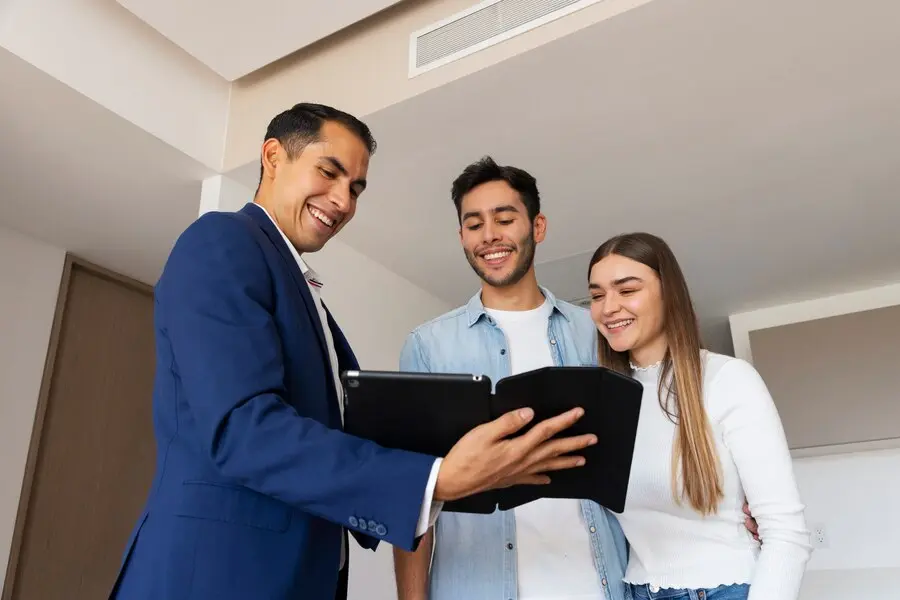 Agente inmobiliario brindando asesoramiento a clientes interesados en agencia inmobiliaria.