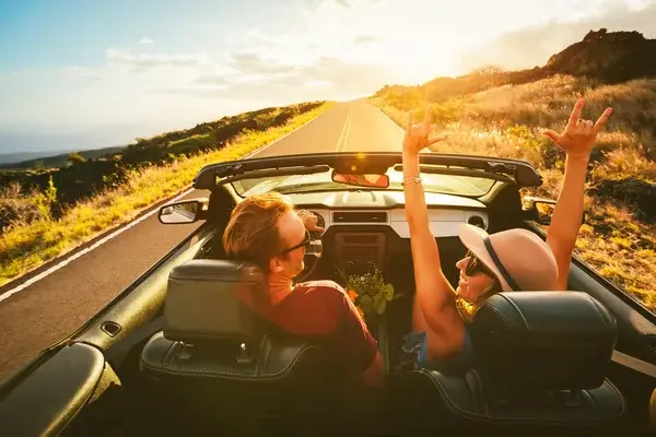 dos personas en su carro disfrutando de viajar por carretera