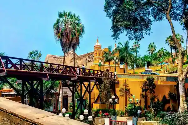 puente de madera frente a una iglesia