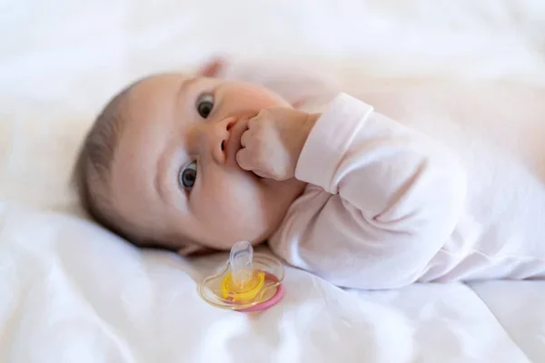 Bebé con el chupón al lado porque su mamá se pregunta sí es bueno el chupón para los bebés
