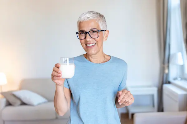 Señora sosteniendo un vaso con kéfir