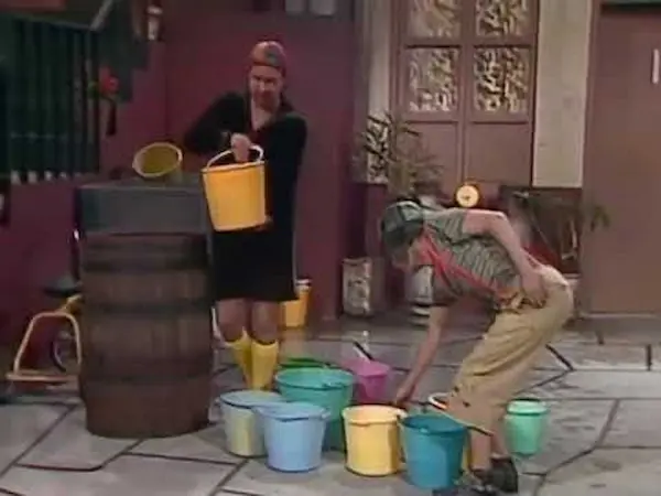 Vecinos cargando agua en cubetas durante la escasez en la vecindad.