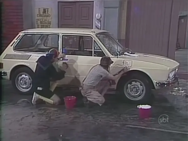 El Chavo intentando limpiar el carro del Señor Barriga con resultados desordenados.