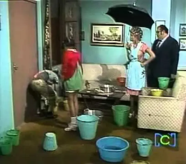 Interior de la casa con goteras y cubetas para contener el agua.