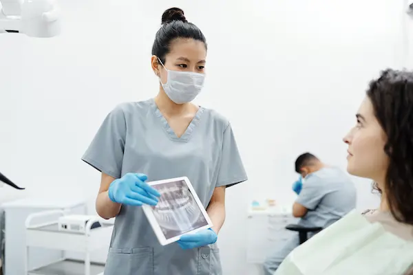 Odontólogo explicando una radiografía dental durante una consulta de evaluación