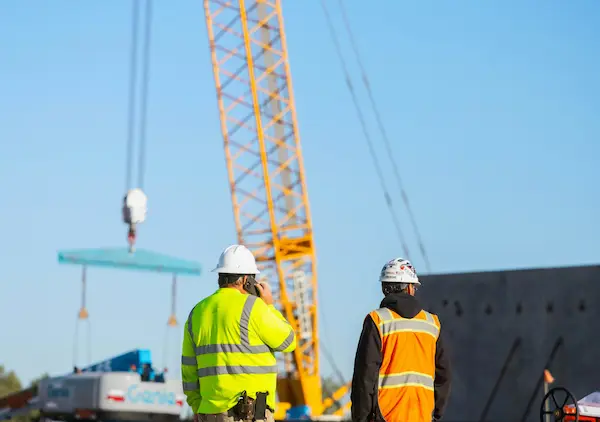 Trabajadores supervisando una operación con grúa