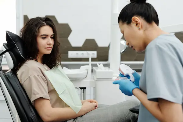 profesional explicando procedimientos odontológicos con un modelo dental
