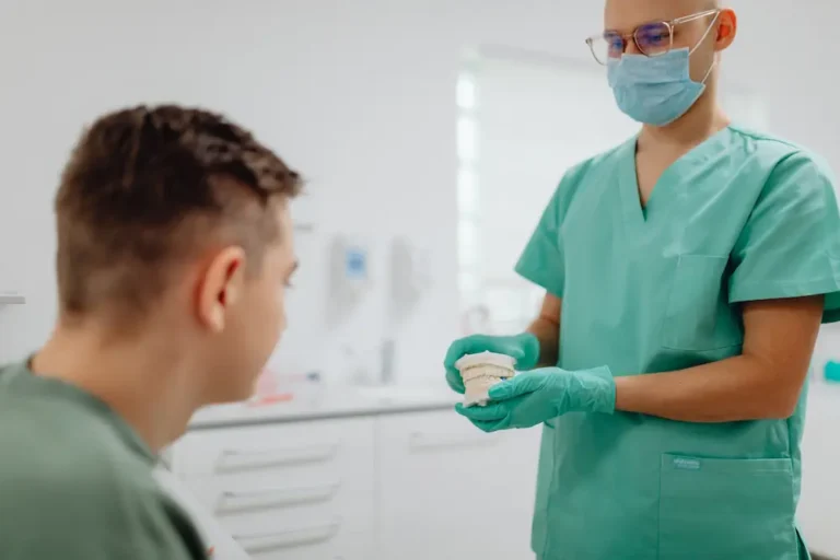Odontólogo explicando opciones de tratamiento dental a un paciente en consulta