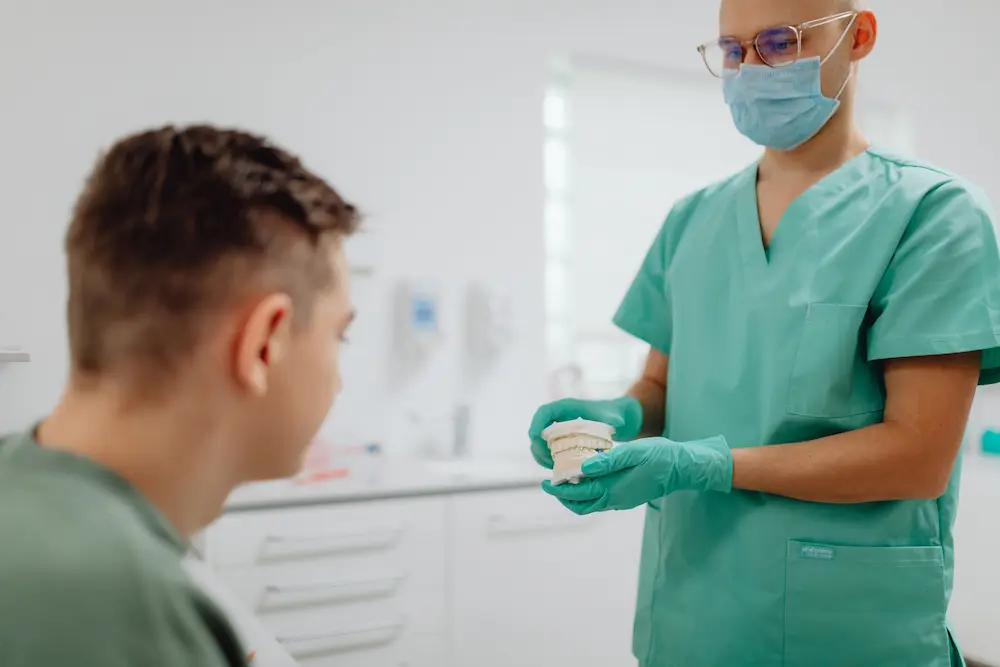 Odontólogo explicando opciones de tratamiento dental a un paciente en consulta