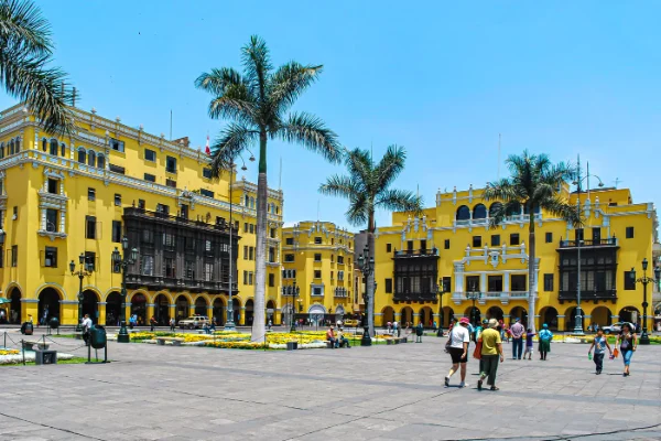 Plaza Mayor de Lima con palmeras y edificios coloniales amarillos